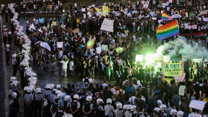 Riot policemen stand guard as thousands of students shout slogans during a protest of what is now called the 'Tropical Spring' against corruption and price hikes, at National Congress in Brasilia, on June 20, 2013.(AFP Photo / Evaristo SA)