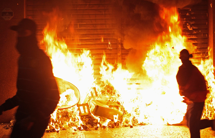 Demonstrators run past burning garbage during protests against poor public services, police violence and government corruption in Sao Paulo June 18, 2013 (Reuters / Alex Almeida)
