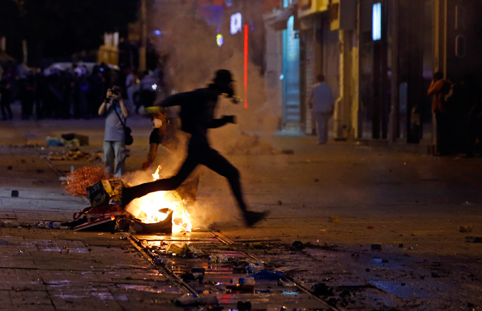 A protester jumps over a fire as he runs from riot police on a street near Taksim Square in Istanbul June 22, 2013 (Reuters / Marko Djurica)