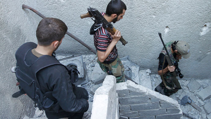 Members of the Free Syrian Army walk down the stairs holding their weapons in Aleppo's Salaheddine district.(Reuters / Hamid Khatib)