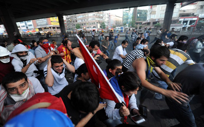 People run away from tear gas after they cross the Bosphorus bridge by wallking from Anatolian side to European side near Taksim square in Istanbul, on June 16, 2013. (AFP Photo / Bulent Kilic)