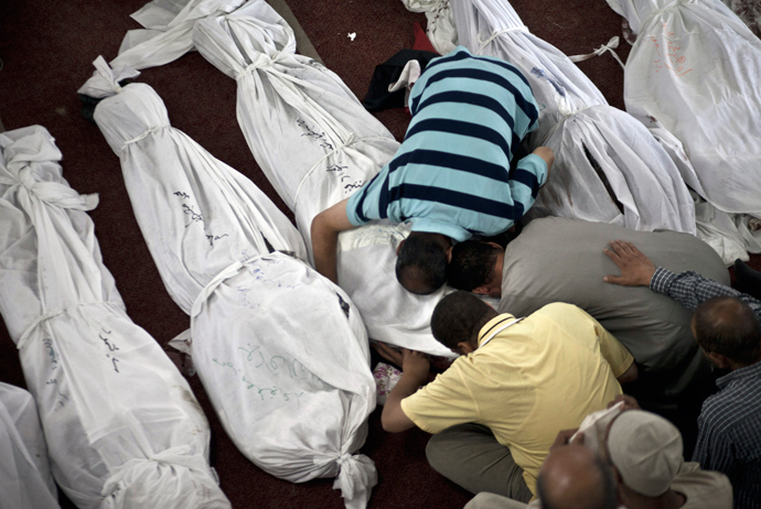 Egyptians mourn over a body wrapped in shrouds at a mosque in Cairo on August 15, 2013, following a crackdown on the protest camps of supporters of ousted Islamist president Mohamed Morsi the previous day (AFP Photo / Mahmoud Khaled)
