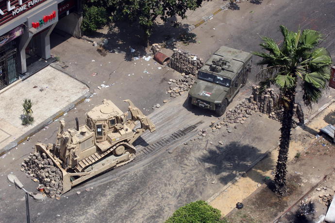 Army bulldozers remove a barricade errected by supporters of ousted president Mohamed Morsi during clashes with riot police at Cairo's Mustafa Mahmoud Square on August 14, 2013 (AFP Photo / Str)
