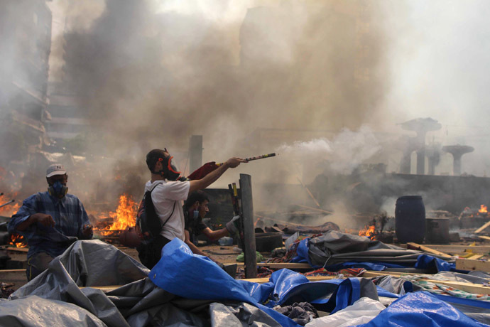 A supporter of the Muslim Brotherhood and Egypt's ousted president Mohamed Morsi fires fireworks towards police during clashes in Cairo on August 14, 2013, as security forces backed by bulldozers moved in on two huge pro-Morsi protest camps, launching a long-threatened crackdown that left dozens dead. (AFP Photo/Mosaab El-Shamy)