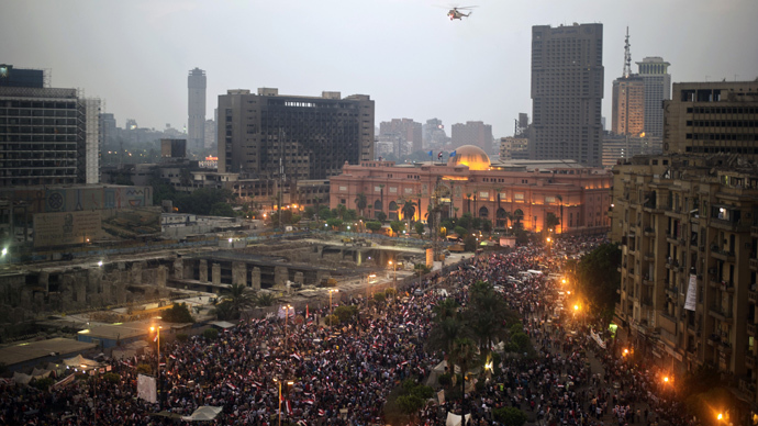 An Egyptian army helicopter flies over protesters calling for the ouster of President Mohamed Morsi in Cairo's landmark Tahrir Square on July 3, 2013 (AFP Photo / Gianluigi Guercia) 