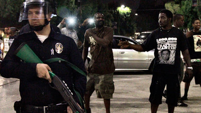 Two men stand near a Los Angeles police officer during a protest against the acquittal of George Zimmerman in the Trayvon Martin trial in Los Angeles, California July 15, 2013.(Reuters / Jonathan Alcorn)