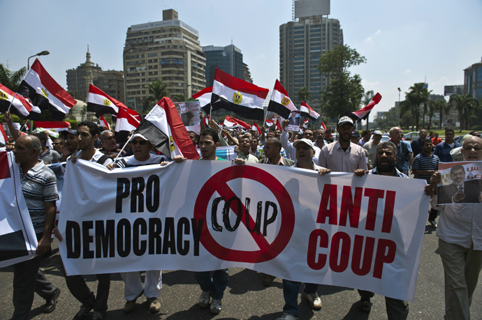 Supporters of the Muslim Brotherhood and toppled Egyptian president Mohamed Morsi hold a banner against his ouster as they march towards Cairo University to demand his reinstatement in Cairo on July 19, 2013 (AFP Photo / Khaled Desouki)