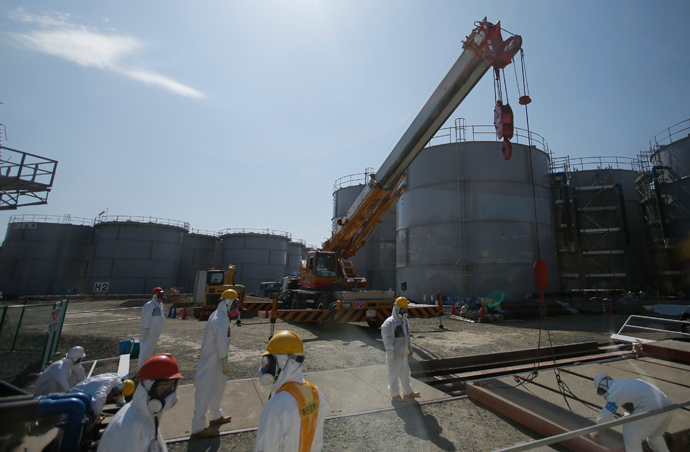 Workers wearing protective suits and masks are seen near tanks of radiation contaminated water at Tokyo Electric Power Co's (TEPCO) tsunami-crippled Fukushima Daiichi nuclear power plant in the town of Okuma, Fukushima prefecture (AFP Photo / Issei Kato)