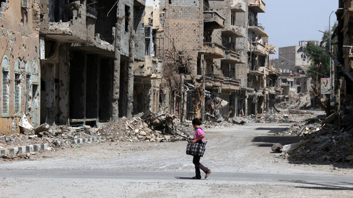 A Syrian girl crosses the street holding a bag in the centre of Syria's northeastern city of Deir Ezzor.(AFP Photo / Abo Shuja)