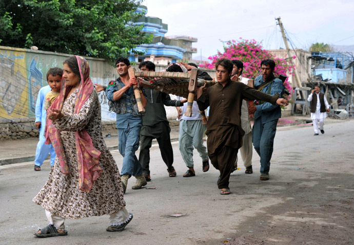 Afghan volunteers and security personnel carry a wounded man at the site of a suicide attack in front of the Indian consulate in Jalalabad on August 3, 2013. (AFP Photo/Noorullah Shirzada)