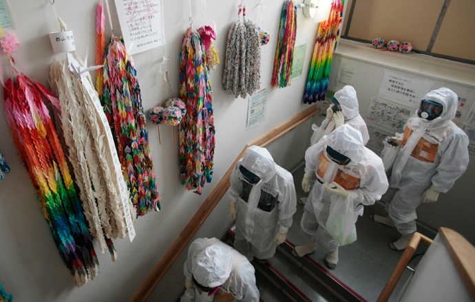 Members of the media and TEPCO employees walk alongside a wall lined with thousands of paper cranes during a media tour at Tokyo Electric Power Company's (TEPCO) tsunami-crippled Fukushima Daiichi nuclear power plant (Reuters / Noboru Hashimoto / Pool)