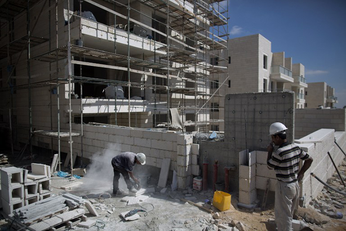 Laborers work at the construction site of a new housing project at the Jewish settlement of Gilo in Israeli annexed Arab east Jerusalem on August 12, 2013. (AFP Photo / Menahem Kahana)