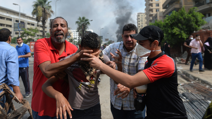 Supporters of Egypt's ousted president Mohamed Morsi and members of the Muslim Brotherhood run from tear gas smoke shot by police to disperse a pro-Morsi camp, on August 14, 2013 in Cairo (AFP Photo / Khaled Desouki)