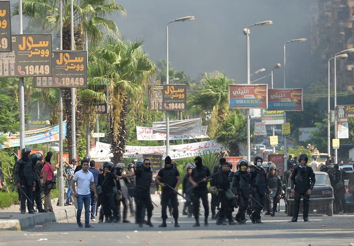 Egyptian riot police disperse supporters of Egypt's ousted president Mohamed Morsi and members of the Muslim Brotherhood as security forces crackdown on two major pro-Morsi protest camps, on August 14, 2013 near Cairo's Rabaa al-Adawiya mosque (AFP Photo / Khaled Desouki)
