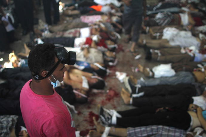 A man looks at bodies laid out in a make shift morgue after Egyptian security forces stormed two huge protest camps at the Rabaa al-Adawiya and Al-Nahda squares where supporters of ousted president Mohamed Morsi were camped, in Cairo, on August 14, 2013 (AFP Photo / Mosaab El-Shamy)