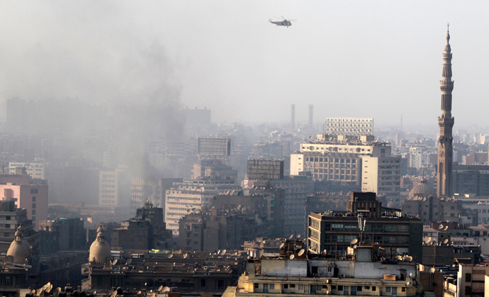 A military helicopter flies over clouds of smoke after clashes between members of the Muslim Brotherhood and supporters of ousted Egyptian President Mohamed Mursi at Azbkya police station during clashes at Ramses Square in Cairo, August 16, 2013 (Reuters / Amr Abdallah Dalsh)
