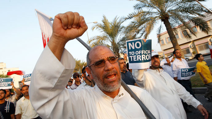 An anti-government protester holding Bahraini flags and signs saying "No To Official Terror" march during a rally organized by Bahrain's main opposition party Al Wefaq on Budaiya highway west of Manama August 23, 3013. (Reuters / Hamad I Mohammed)