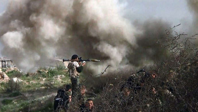 An image grab taken from a video shows opposition fighter holding a rocket propelled grenade (RPG) as his fellow comrades take cover from an attack by regime forces during clashes over the strategic area of Khanasser, situated on the only road linking Aleppo to central Syria. (AFP Photo / Salah Al-Ashkar)