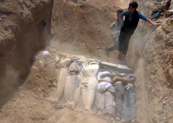 An image grab taken from a video uploaded on YouTube by the Local Committee of Arbeen on August 21, 2013 allegedly shows Syrians covering a mass grave containing bodies of victims that Syrian rebels claim were killed in a toxic gas attack by pro-government forces in eastern Ghouta and Zamalka, on the outskirts of Damascus. (AFP Photo)