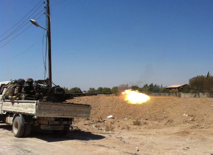 Syrian troops fire a heavy machine gun mounted on a pick-up truck in the Eastern Ghouta area on the northeastern outskirts of Damascus on August 30, 2013 (AFP Photo / Sam Skaine)
