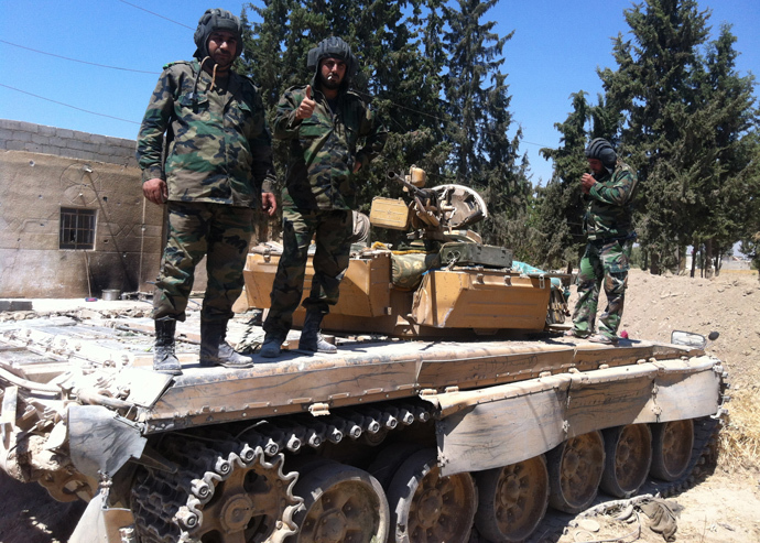 A Syrian soldier gives a thumbs-up as he stands on top of a tank alongside two fellow soldiers in the Eastern Ghouta area on the northeastern outskirts of Damascus on August 30, 2013 (AFP Photo / Sam Skaine)