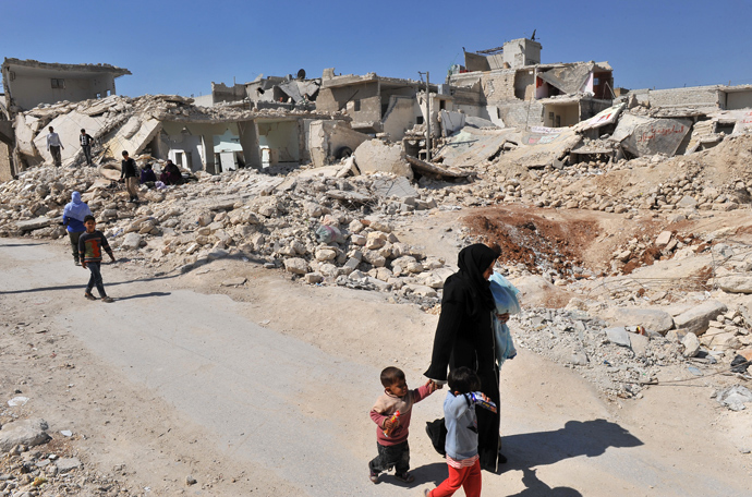 Syrians walk past destroyed buildings in the northern city of Aleppo (AFP Photo)