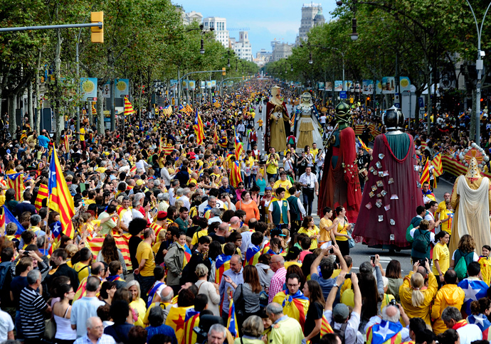 Giants walk past Catalans gathering in a bid to create a 400-kilometre (250-mile) human chain, part of a campaign for independence from Spain during Catalonia National Day, or Diada, on Passeig de Gracia in Barcelona, on September 11, 2013 (AFP Photo / Josep Lago)