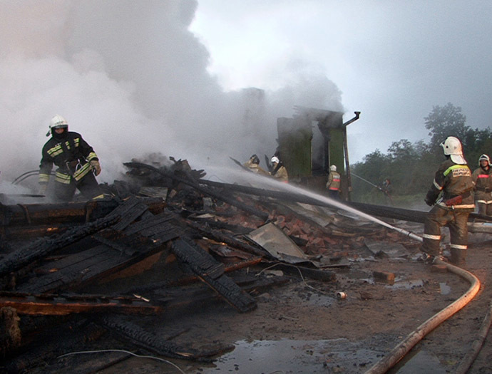 Rescuers are searching the debris while firefighters are extinguishing flames at the Oksochi psychiatric hospital in the village of Luka, Novgorod Region, September 13. (RIA Novosti)