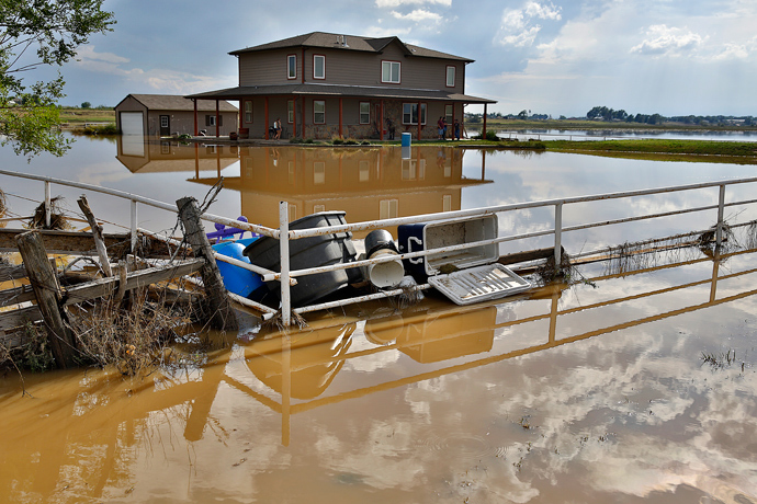Debris gathers in the corner of a fence in front of a home on September 14, 2013 in La Salle, Colorado (AFP Photo / Marc Piscotty)