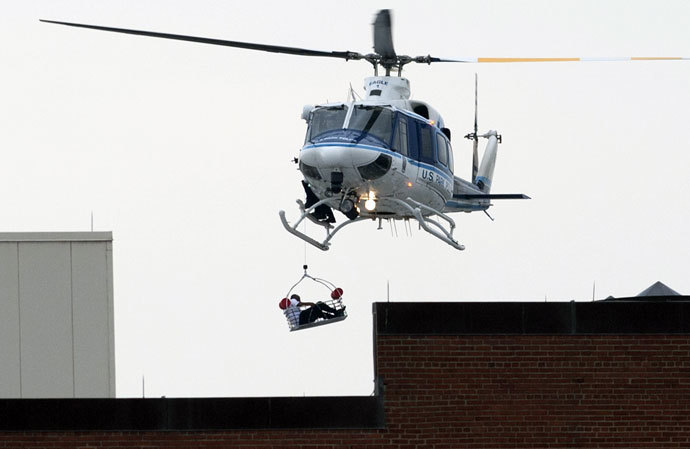 A helicopter lifts a person off the roof as police respond to the report of a shooting at the Navy Yard in Washington, Dc on September 16, 2013.(AFP Photo / Saul Loeb)