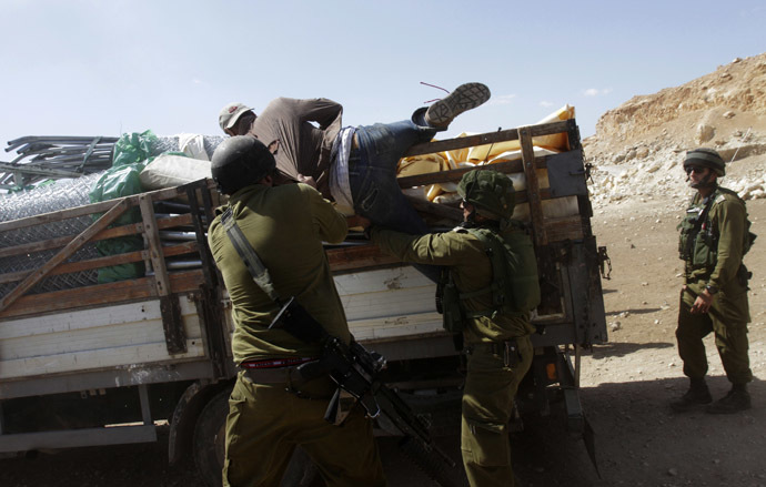 sraeli soldiers pull a Palestinian off a truck loaded with items European diplomats wanted to deliver to locals in the West Bank herding community of Khirbet al-Makhul, in the Jordan Valley September 20, 2013. (Reuters/Abed Omar Qusini)
