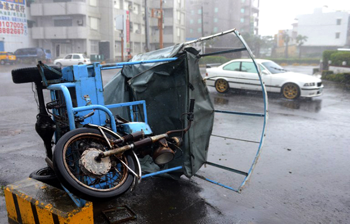 A three-wheeled vehicle lies on its side after being blown over by winds from Typhoon Usagi in the town of Hengtsun in southeast Pingtung county on September 21, 2013 as the storm sweeps past the southern parts of the island. (AFP Photo / Sam Yeh)