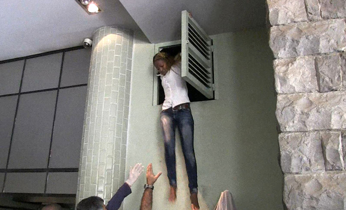 An image grab taken from AFP TV shows a Kenyan woman coming out of an air vent where she was hiding during an attack by masked gunmen at a shopping mall in Nairobi on September 21, 2013 (AFP Photo / AFPTV)