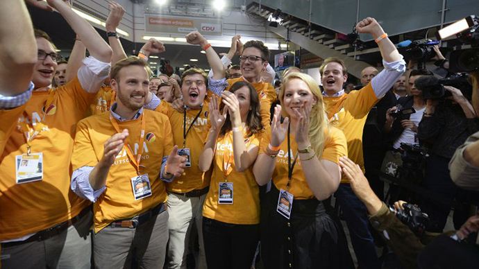 Supporters of the Christian Democratic Union (CDU) celebrate as exit polls are broadcast on television in Berlin on September 22, 2013, after the German general elections. (AFP Photo / Odd Andersen)