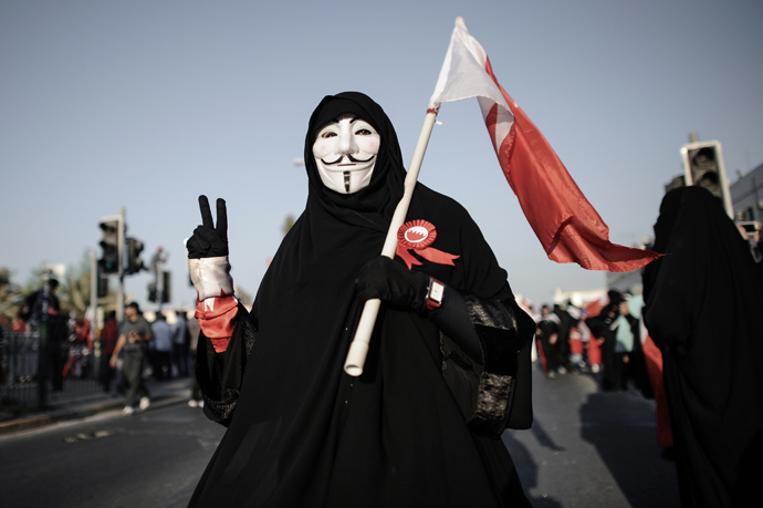 A Bahraini woman wearing a Guy Fawkes mask used by the Anonymous movement flashes the 'V-sign' for victory during an anti-government protest in the village of Jannusan, west of the capital Manama, on September 27, 2013 (AFP Photo / Mohammed Al-Shaikh)