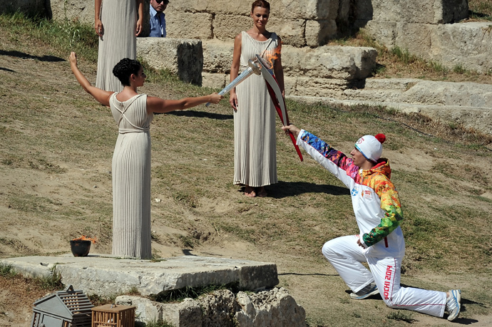 Greek actress Ino Menegakie acting as the priestesses passes the flame to the first torch bearer, Greek skier Giannis Anoniou, at the Temple of Hera on September 29, 2013 during the lighting ceremony in ancient Olympia (AFP Photo / Louisa Gouliamaki)
