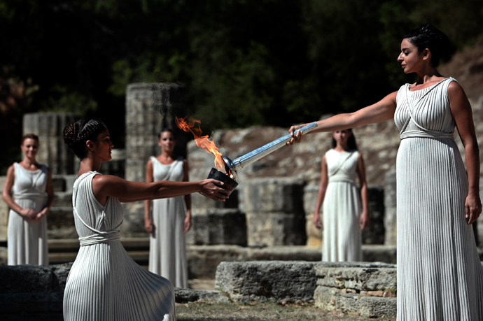 Greek actress Ino Menegaki acting as the high priestess passes the Olympic Flame at the Temple of Hera on September 29, 2013 during the lighting ceremony in ancient Olympia (AFP Photo / Aris Messinis)