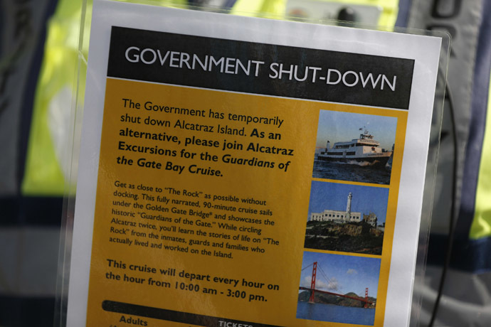 Security officer Jarvis Landlum holds a sign informing people on the government shutdown of Alcatraz Island, a tourist attraction operated by the National Park Service, in San Francisco, California October 1, 2013. (Reuters/Stephen Lam)