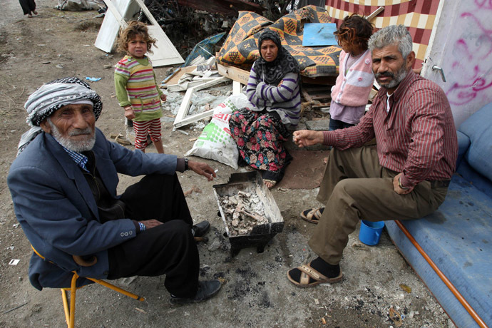 Syrian children refugees, who flock by dozens in Turkey each day, fleeing the civil war in their country, sit on October 4, 2013 at a makeshift camp in Ankara, where they arrived three months ago. In the central public Dikmen valley park in front of the eyes of local authorities, they build a shanty town. (AFP Photo)