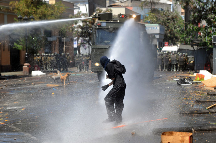 Students clash with riot police during a protest to demand Chilean President Sebastian Pinera's government to improve the public education quality, in Santiago, on October 17, 2013. (AFP Photo/Hector Retamal)