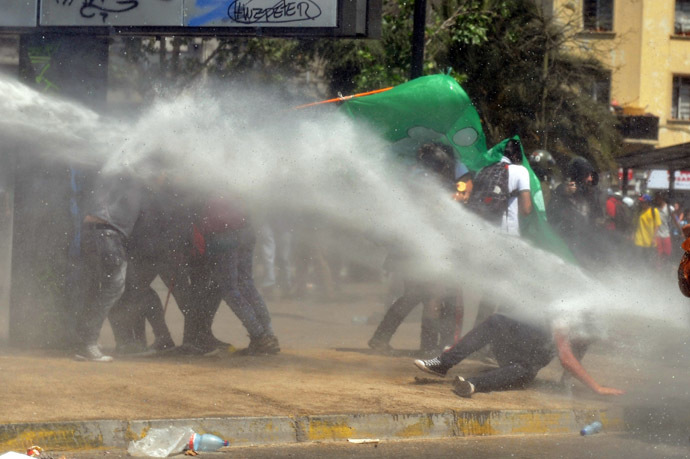 Students clash with riot police during a protest to demand Chilean President Sebastian Pinera's government to improve the public education quality, in Santiago, on October 17, 2013. (AFP Photo/Hector Retamal)