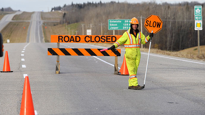 A Parkland County employee blocks a highway leading to an area where a train derailed, in the small town of Gainford, Alberta west of Edmonton October 19, 2013. (Reuters / Dan Riedlhuber)