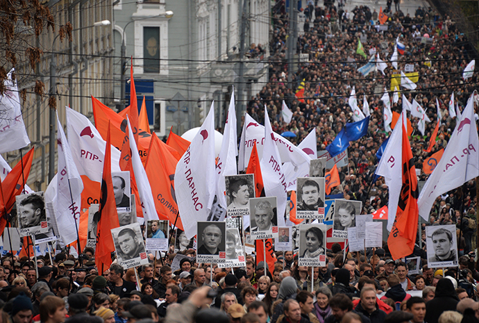 People carry pictures of political prisoners during an opposition rally in central Moscow on October 27, 2013. (RIA Novosti / Ilya Pitalev)