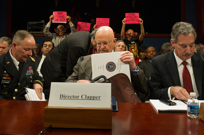 Protesters with the organization Code Pink hold up placards as Director of National Security Agency (NSA) and Commander of US Cyber Command General Keith Alexander (L), Director of National Intelligence James Clapper (C) and Deputy Attorney General James Cole (R) arrive to testify before the House (Select) Intelligence Committee on "Potential Changes to the Foreign Intelligence Surveillance Act (FISA)" on Capitol Hill in Washington, DC, October 29, 2013 (AFP Photo / Jim Watson)