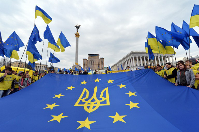 Activists of Ukrainian movement "For European Future" hold EU flag with the Ukraine national emblem during their rally at Independence Square in Kiev on October 30, 2013. (AFP Photo / Sergei Supinsky)