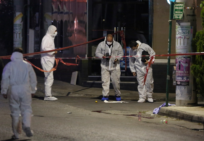 Police forensic experts search for evidence outside the local offices of far-right Golden Dawn party, following a shooting, in a northern suburb of Athens November 1, 2013 (Reuters / John Kolesidis)