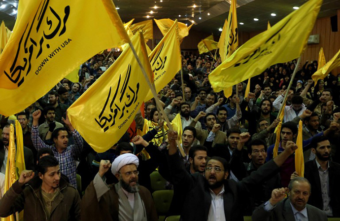 Iranians from the Islamic hardline Basiji volunteer militia, hold flags reading "Down with USA" as they take part in a protest against America inside the former US embassy in Tehran on November 2, 2013. (AFP Photo / Atta Kenare)