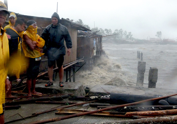 People stand at the pier as Super Typhoon Haiyan smashes into coastal communities on the central island of Bacalod on November 8, 2013. (AFP Photo / Julius Mariveles)