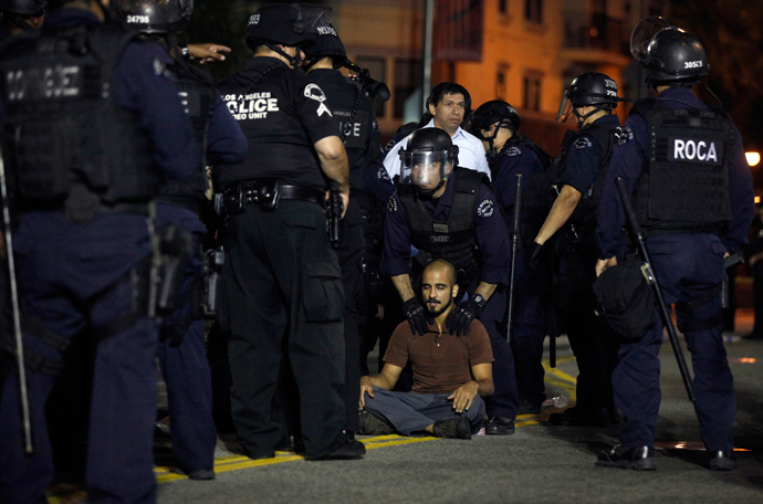 A protester sits in the middle of the road during a demonstration for better wages outside Wal-mart in Los Angeles, November 7, 2013. (Reuters / Lucy Nicholson)