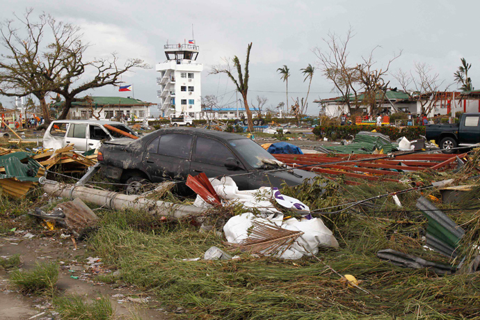 Vehicles that were washed away by floodwaters are seen at a rice field near the airport after super Typhoon Haiyan battered Tacloban city, central Philippines, November 9, 2013 (Reuters / Romeo Ranoco)